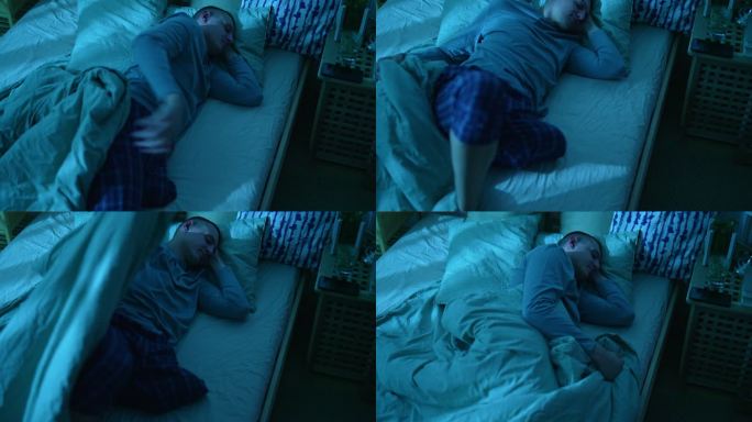 一个腿部截肢的残疾年轻人晚上睡在床上不安
