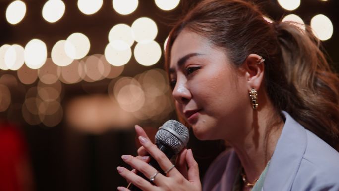 年轻的亚洲女性喜欢在晚上唱卡拉ok音乐