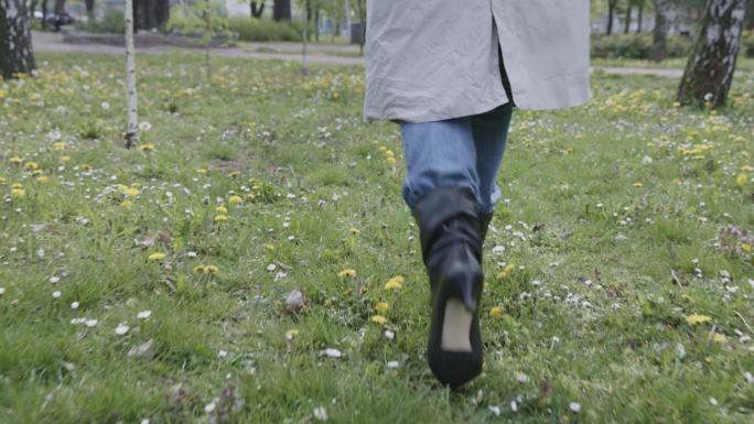 一张无法辨认的女子穿过公园草地的追踪照片