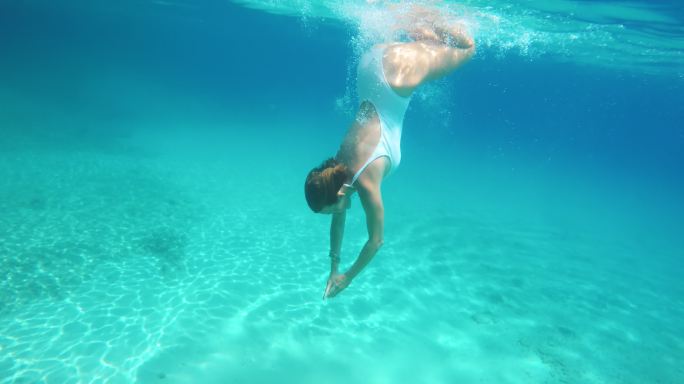 中景：女子在蓝海中游泳