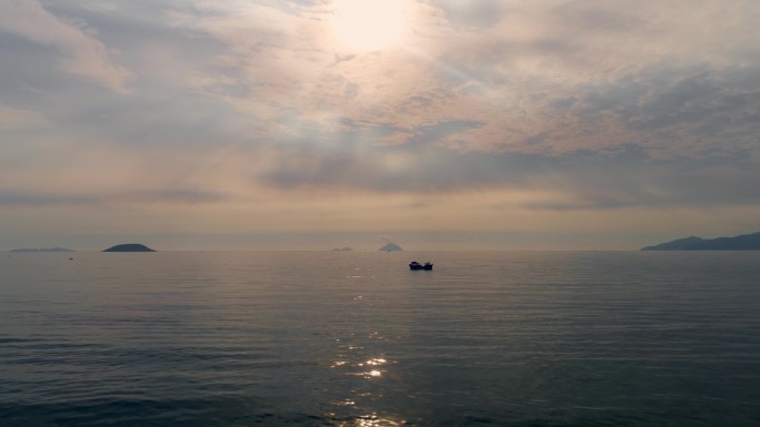 海上渔船海上渔船捕鱼逆光晚霞阳光穿过云层