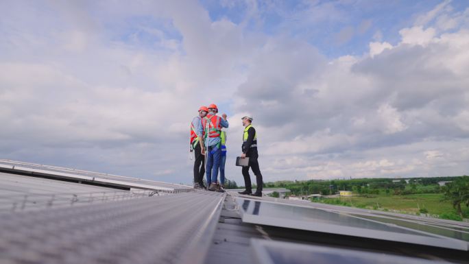 成功的团队，技术人员在工厂屋顶安装和维护太阳能电池板。