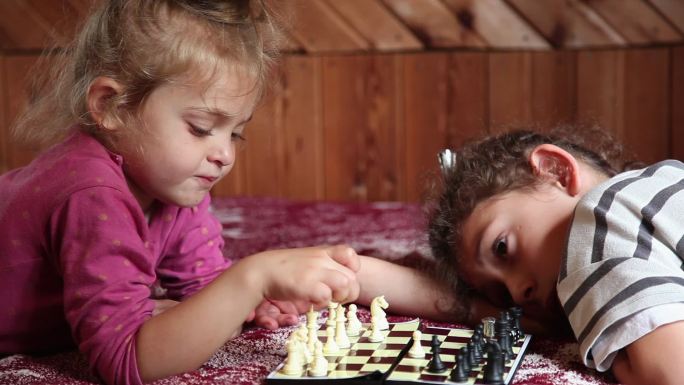 小女孩在床上下棋的侧视图