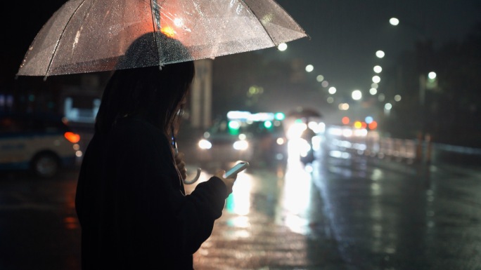 夜晚女孩用手机软件打车回家