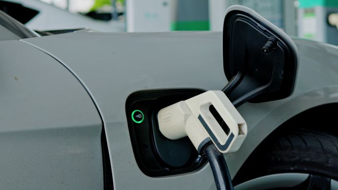 在停车场或加油站为车辆充电。电动汽车充电站。纯能源对未来世界是环保的。