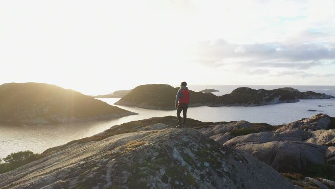 一位女性户外探险的无人机视图：在挪威峡湾边的山上徒步旅行