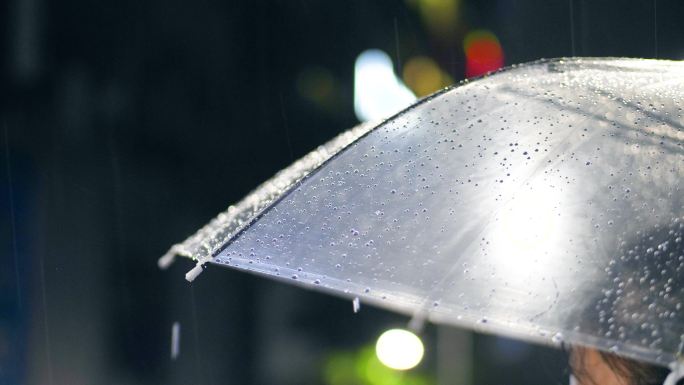 透明雨伞上的雨滴滴落下来视频素材