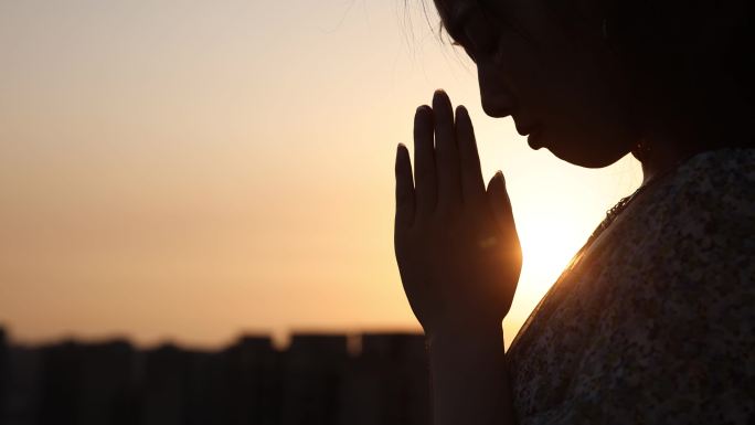 女人用阳光祈祷平安祝愿双手合十