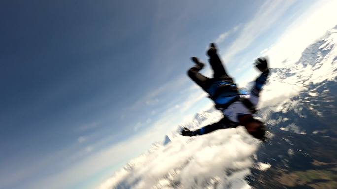 自由落体跳伞者在瑞士山区上空翱翔