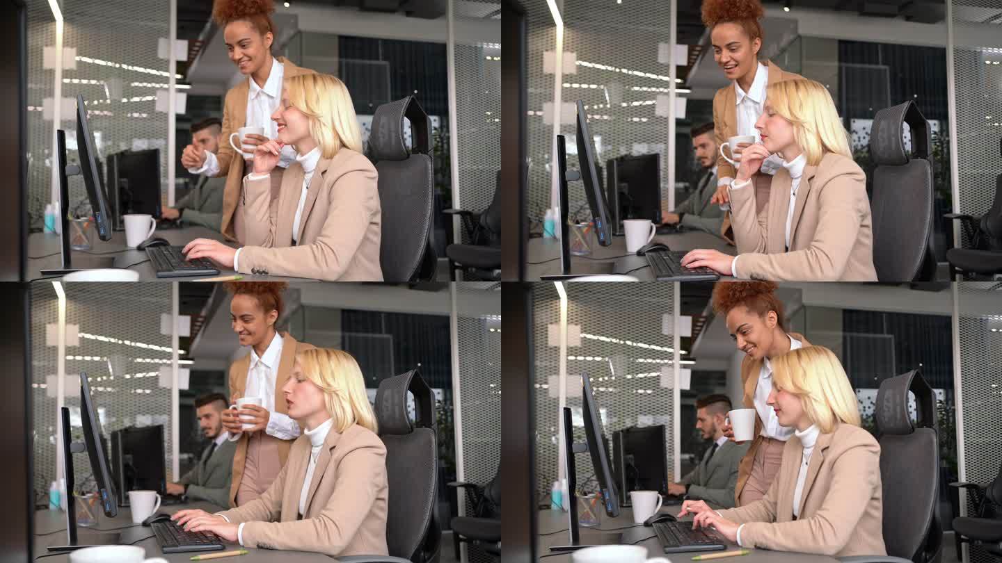混血女经理在电脑前向白人同事竖起大拇指