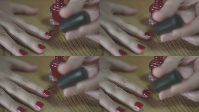 女性在慢动作视频中固定红色指甲漆