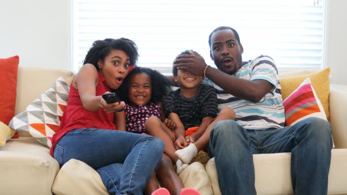 在家看沙发电视的非裔美国人家庭
