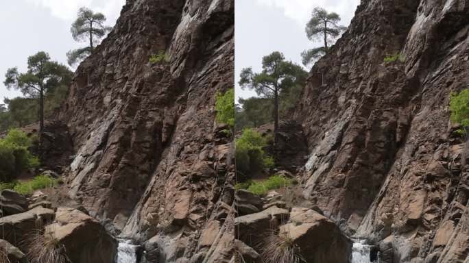 清澈的水流顺着小瀑布倾泻而下，更大的落差落入悬崖边缘的深岩池