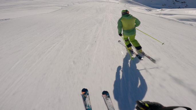 阳光明媚的一天，滑雪者从雪山上下来的第一人称视角