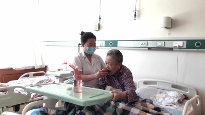 医院护工给老人喂水喂水果护理病人老人服侍