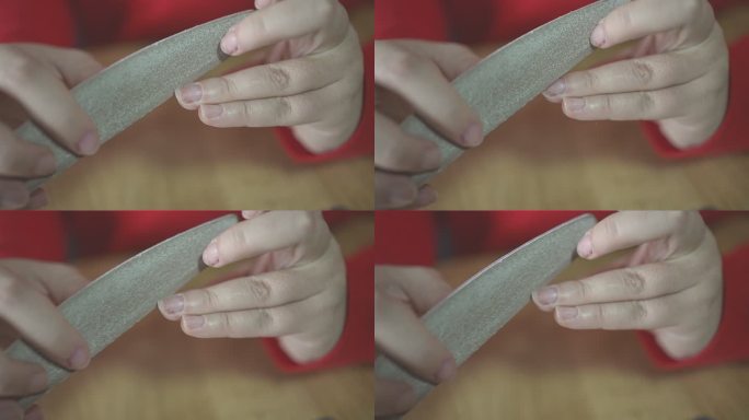 女性在慢动作视频中使用指甲锉塑造指甲
