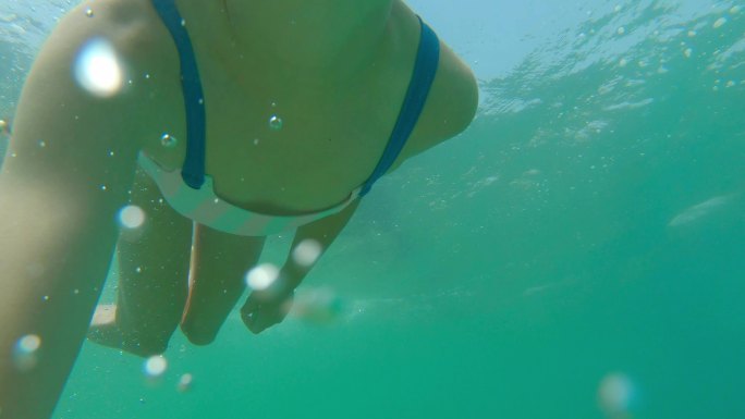 小女孩在水下探索清澈的蓝海