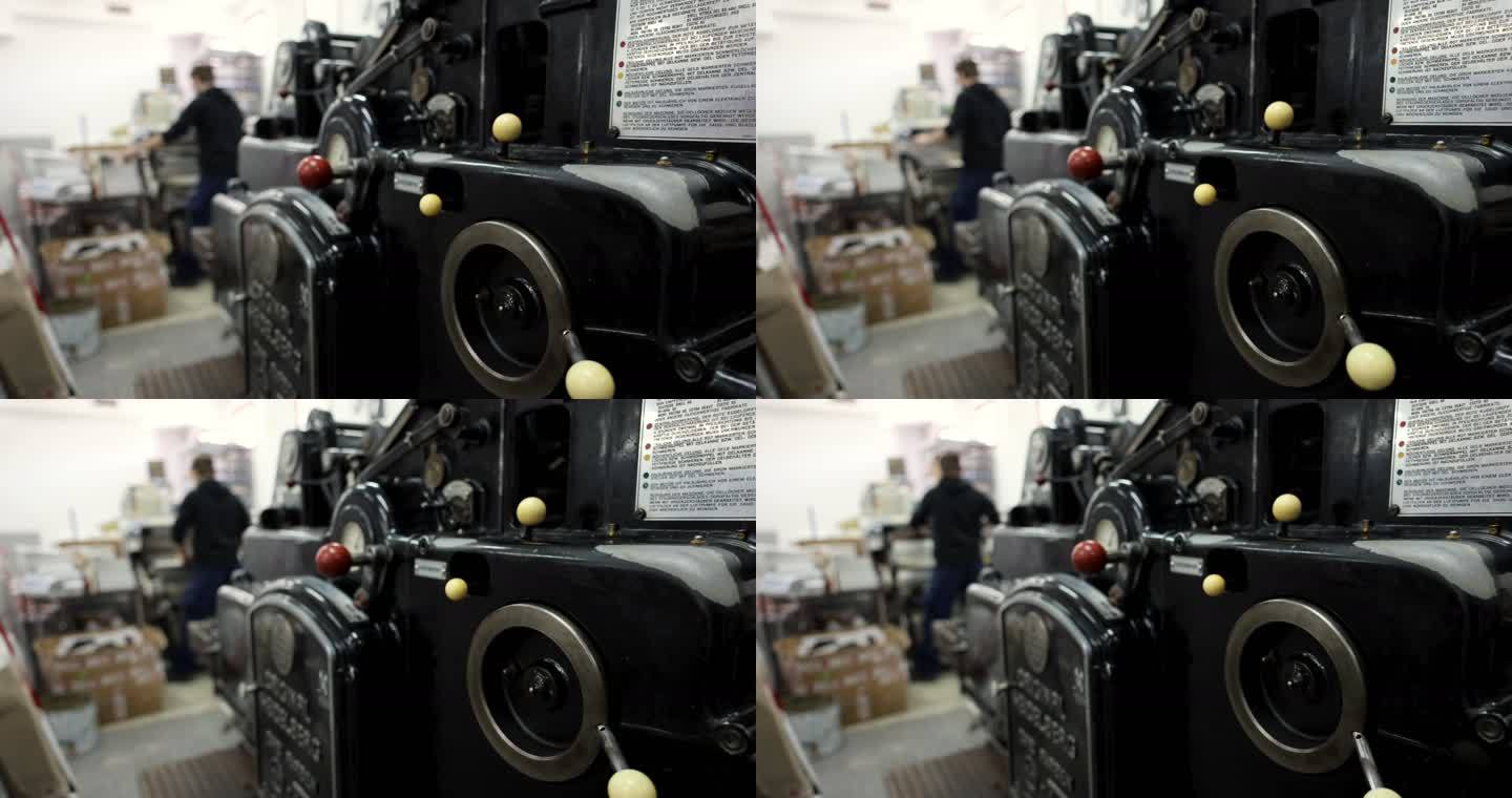 机器分拣和堆叠印刷媒体，而不认识的工人在印刷车间，在后台工作