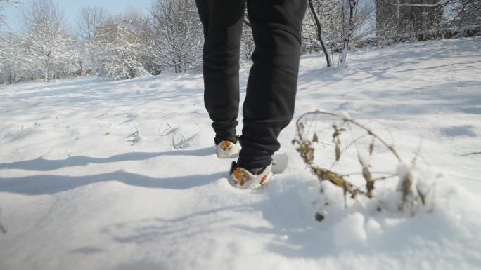 4k慢动作男子雪中行走前进脚步特写