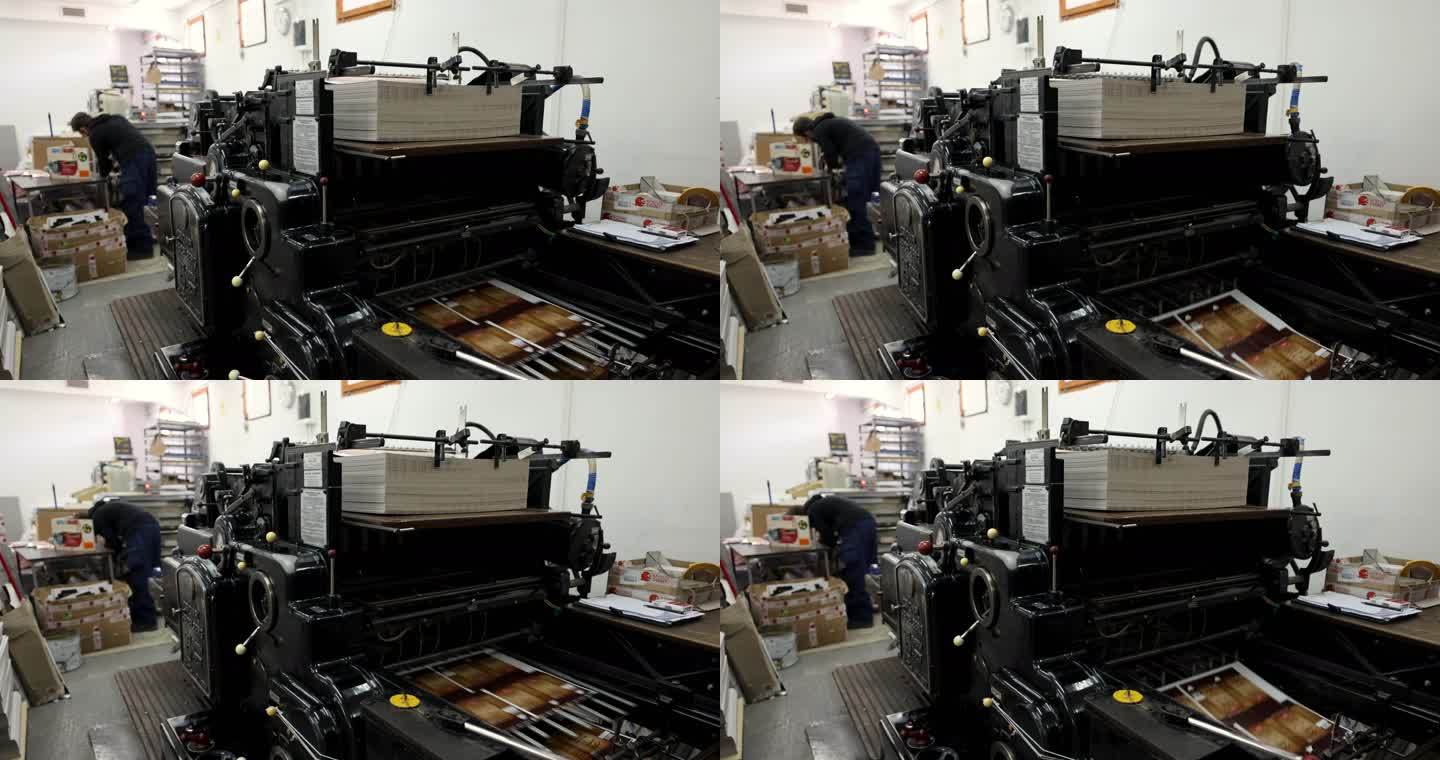 自动机器分拣和堆叠印刷介质，而在印刷车间工作的不知名工人则在后台工作