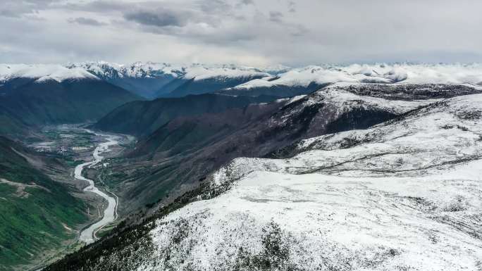 山顶仍被白雪覆盖，深谷被绿色覆盖