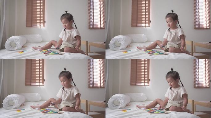 小女孩喜欢在床上玩彩色英文字母玩具