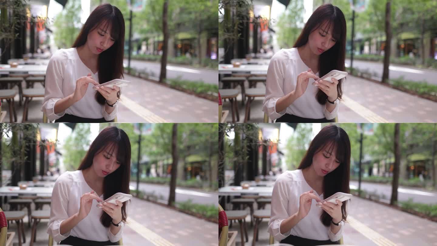 女商人午餐后在户外咖啡馆使用智能手机