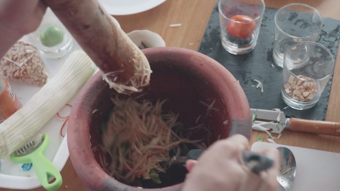 女性烹饪木瓜沙拉（Som Tam）泰国美食