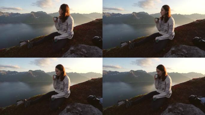 女人坐在Senja山上喝茶