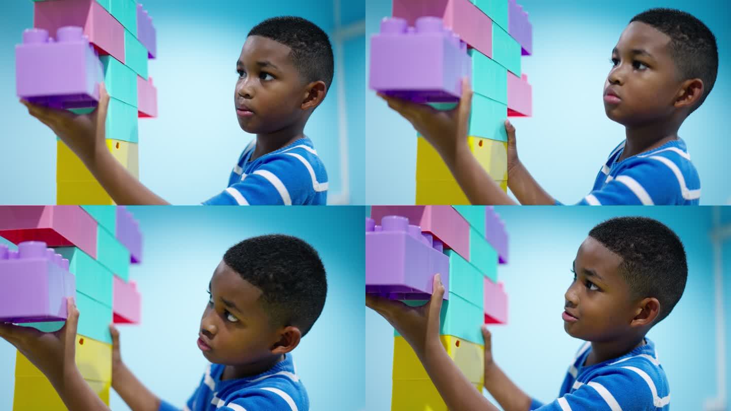 一个7岁的男孩，一个非洲黑人孩子，一个快乐的玩具时光，他专注于连接和增加直线上的彩色塑料积木，使其更