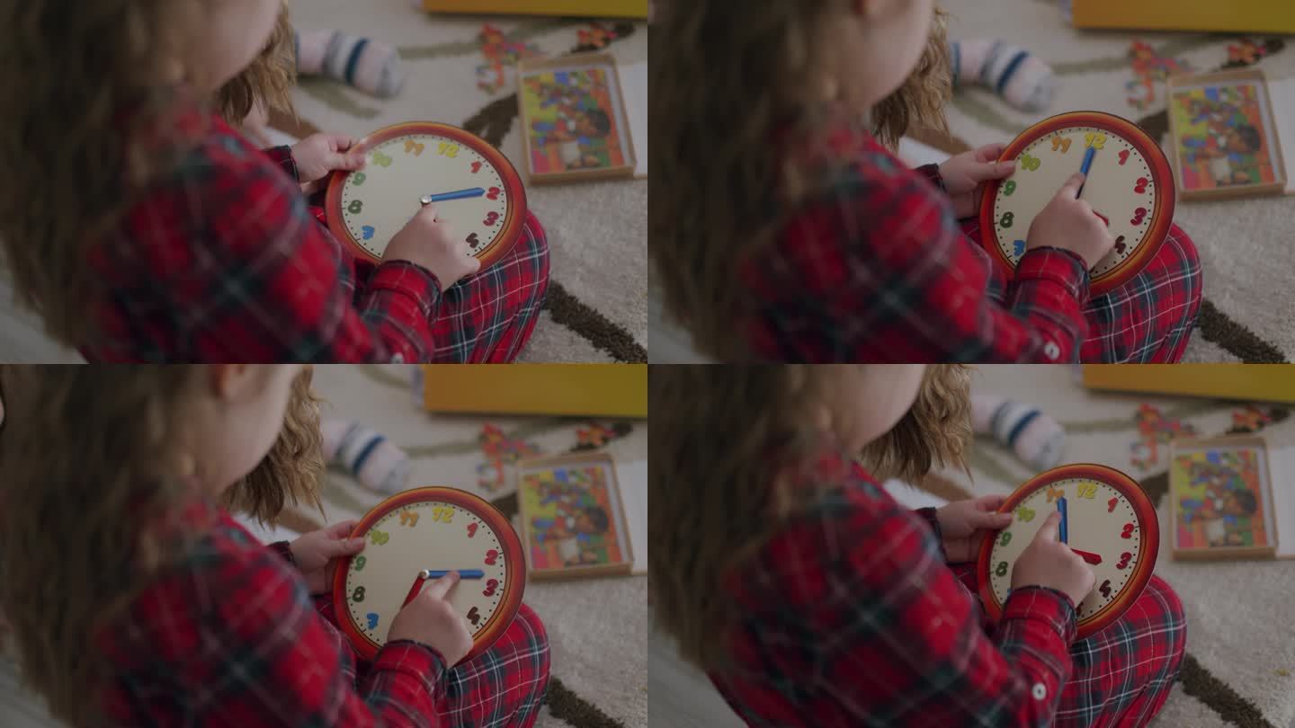 幼儿发展。小女孩在家里用钟玩具学习时间