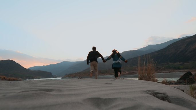 沙滩情侣视频金沙江畔沙滩上奔跑的彝族恋人