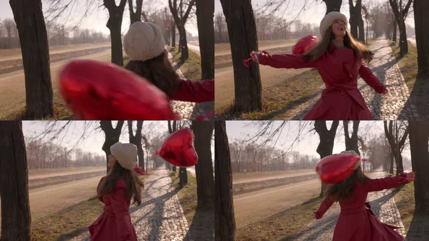 穿着红色外套的女人用红色气球旋转