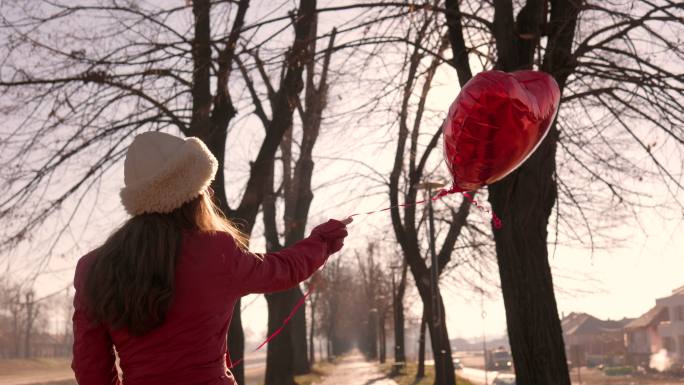 女子向空中释放心脏气球