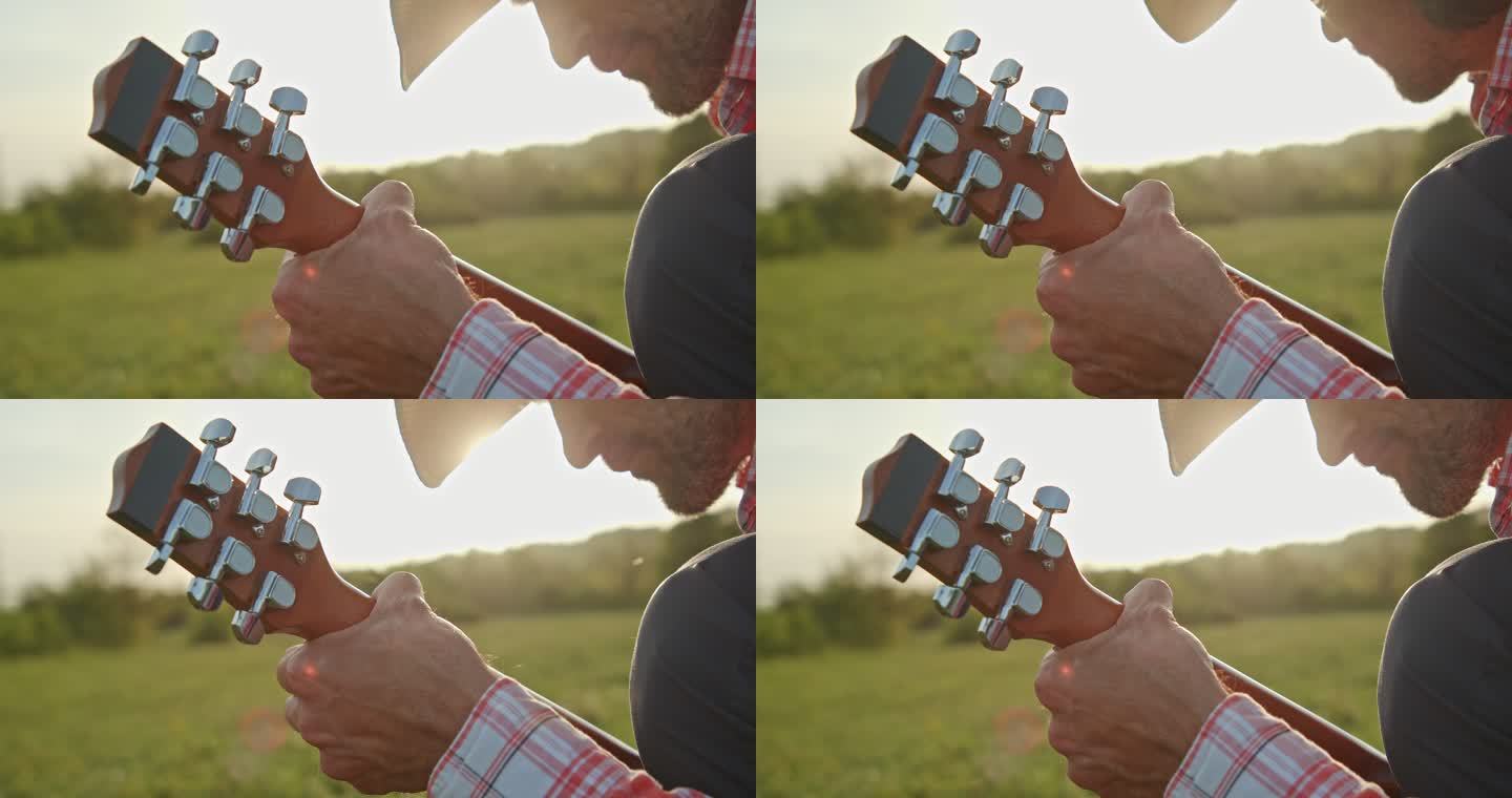 大自然中的牛仔在日落时弹吉他。春季住宿。