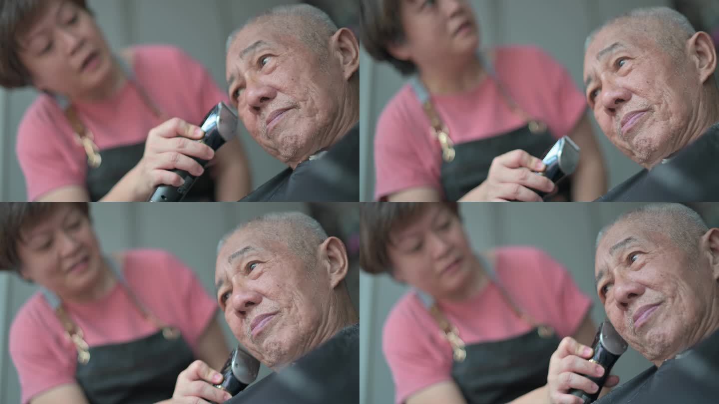 白天在家前院车库的轮椅上为父亲理发的亚裔中国妇女