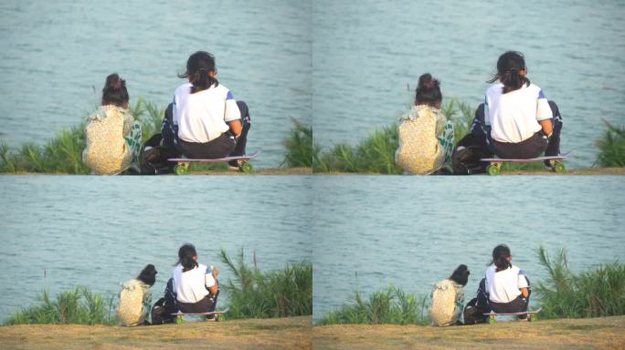 两个小女孩坐在江边