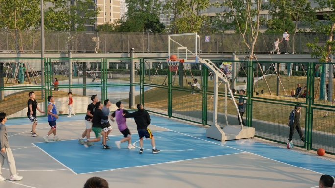 夕阳下打篮球的年轻人 户外篮球场