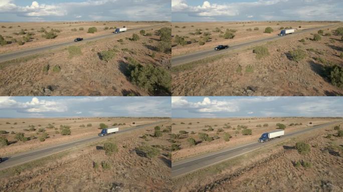 黄昏时分，在戏剧性的天空下，半卡车在犹他沙漠的高速公路上飞驰