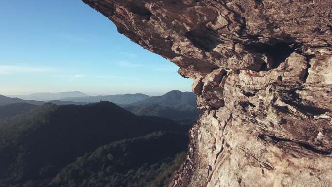空中拍摄的坐在山上悬崖上的女徒步旅行者