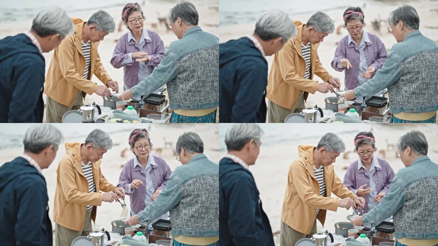 周末休闲活动期间，亚洲的中国老年朋友在停在海滩上的露营车旁准备早餐