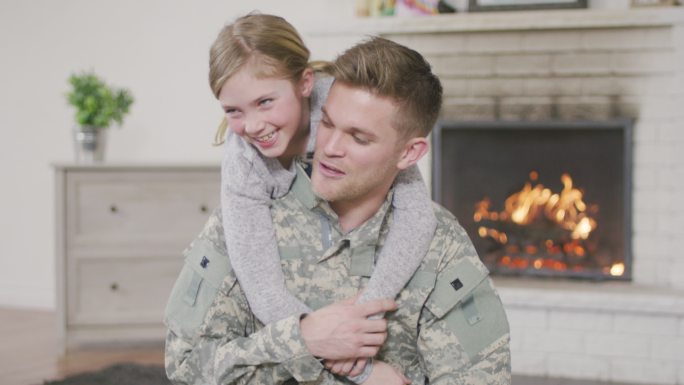 军人爸爸抱着年轻的女儿