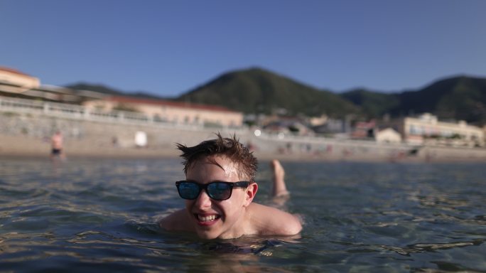 西西里小镇海滩上漂浮的十几岁男孩的肖像
