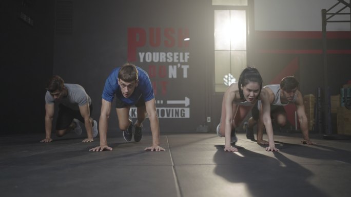 一群朋友在健身房的地板上进行登山训练