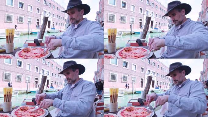 度假时在威尼斯吃披萨的男人。
