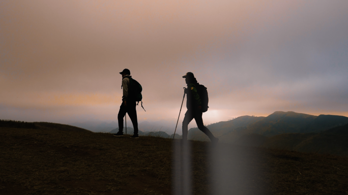 登山行者两位登山者在山顶徒步旅行探险远方
