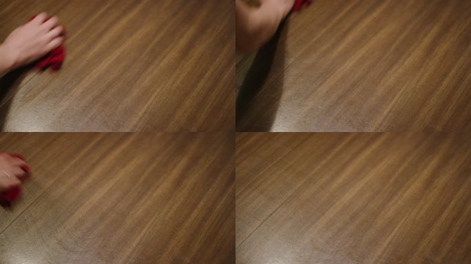 一名高加索妇女的手用红色抹布擦拭木制桌子