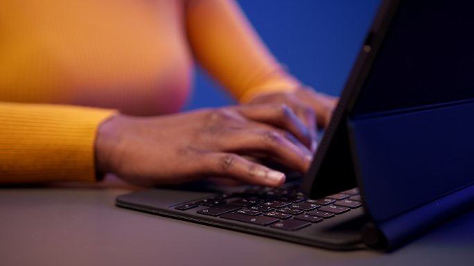 年轻的深色皮肤女子在笔记本电脑上打印