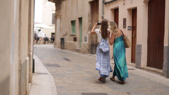 母女俩走在美丽的西班牙小镇狭窄的街道上