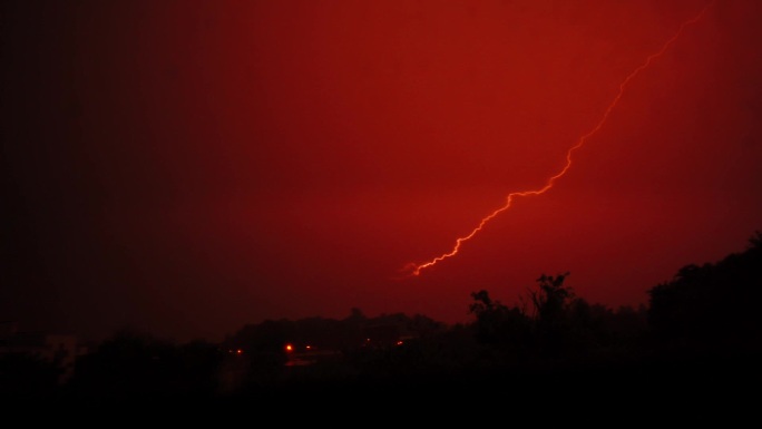 黑色背景上美丽的红色闪电。电气风暴